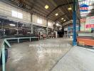 Spacious industrial warehouse interior with machinery and construction materials