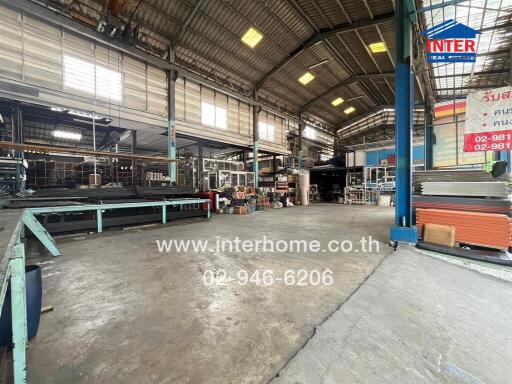 Spacious industrial warehouse interior with machinery and construction materials