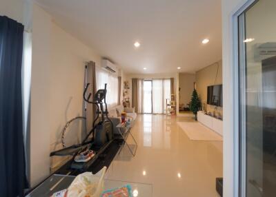 Spacious living room with exercise equipment and balcony access
