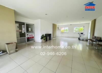 Spacious building lobby with tiled flooring and natural light