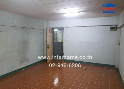Spacious empty room with tiled floors and white walls