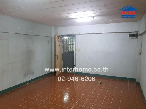 Spacious empty room with tiled floors and white walls