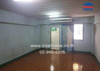 Spacious empty room in a building with tiled floor and air conditioning unit