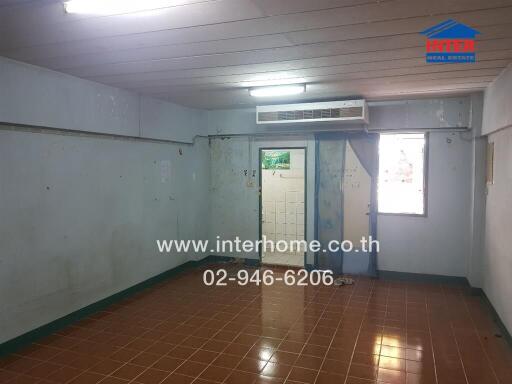 Spacious empty room in a building with tiled floor and air conditioning unit