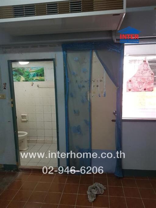 Compact bathroom with blue shower curtain and exterior door
