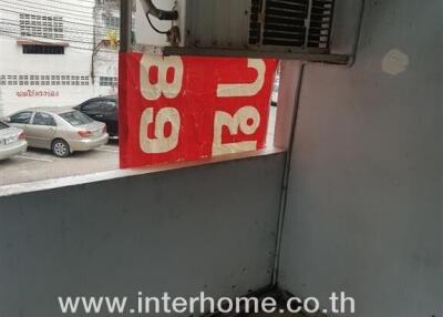 View of building exterior with visible air conditioning unit and signage