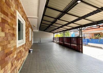 Spacious covered patio with brick walls and tiled flooring
