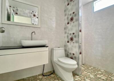 Modern bathroom with white furnishings and decorative tiled wall