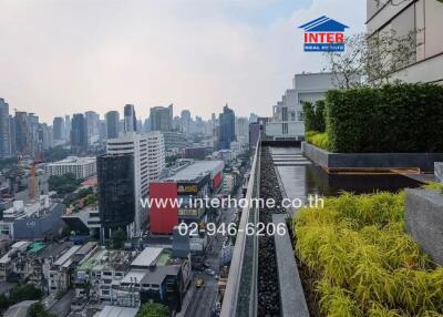 City view from high-rise balcony with lush greenery