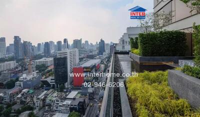 City view from high-rise balcony with lush greenery