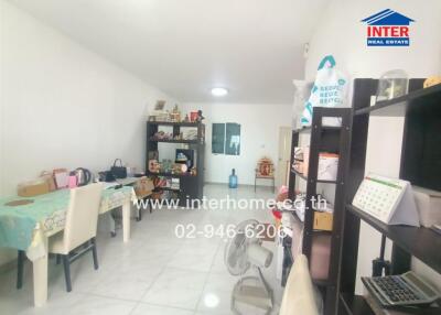 Spacious living room with white walls and tiled flooring featuring multiple storage units