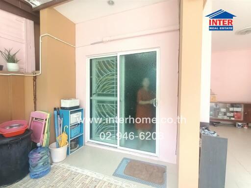 Compact balcony area with storage items and pink walls