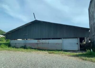 Exterior view of a large industrial building with a metal roof