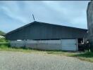 Exterior view of a large industrial building with a metal roof