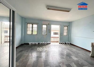 Spacious empty living room with multiple windows and tiled flooring
