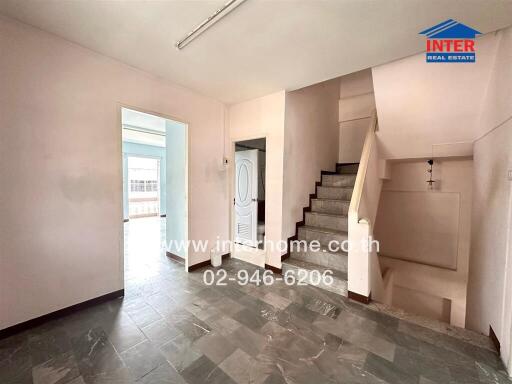 Spacious living room with staircase and balcony access