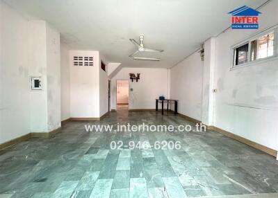 Spacious empty room with grey tile flooring and white walls