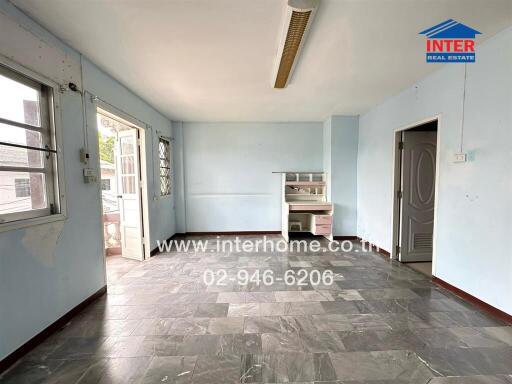Spacious and bright unfurnished living room with large windows and tiled flooring