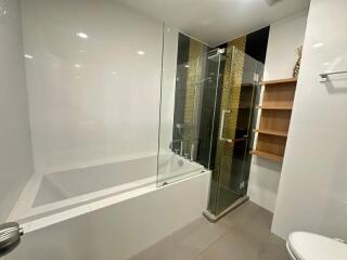 Modern bathroom with bathtub and glass shower partition