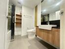Modern bathroom with sleek design, featuring wooden cabinets and a spacious shower area