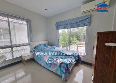 Spacious and well-lit bedroom with air conditioning and large window