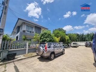 Front view of a residential house with parked vehicles