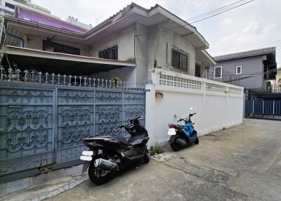 Residential house front view with gated entrance and motorbikes parked outside