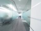 Modern office corridor with glass partitions and conference rooms