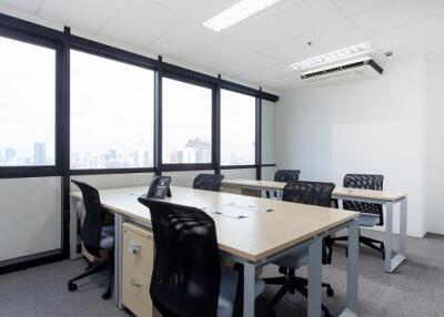 Spacious office room with large windows and city view