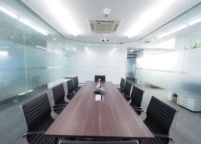 Modern conference room with a large wooden table and black chairs