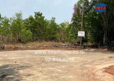 vacant land with a for sale sign and surrounding vegetation