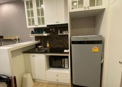 Modern compact kitchen with white cabinetry and black countertops