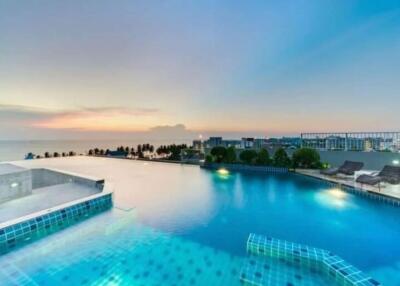 Luxurious outdoor swimming pool overlooking the ocean during sunset