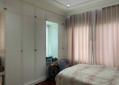 Spacious bedroom with large built-in wardrobes and elegant curtains