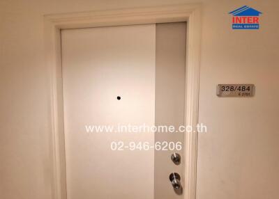 White apartment building door with contact information for Inter Home Real Estate