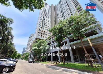 Modern high-rise residential buildings with lush green landscaping and parking