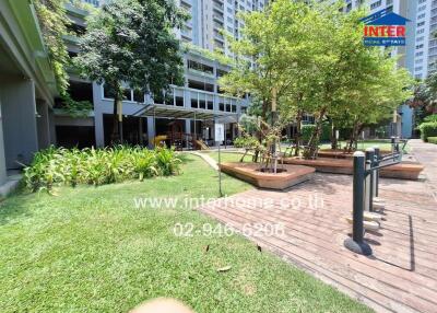 Lush garden and seating area in a residential community with modern buildings in the background