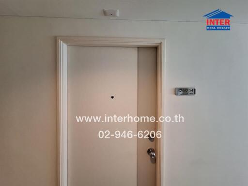 Interior image of a building showing a closed door with contact information for Inter Real Estate