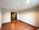 Spacious and brightly lit empty living room with hardwood floors