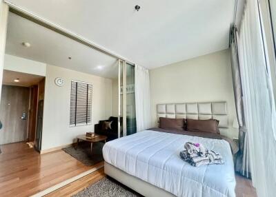 Modern bedroom with large glass windows providing ample natural light