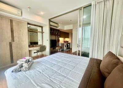 Spacious bedroom with modern design, wooden accents and access to a balcony