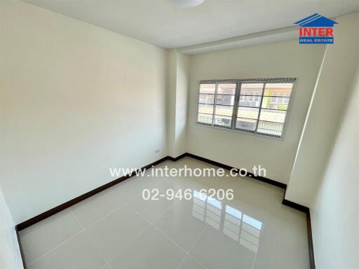 Bright and spacious empty bedroom with large windows and glossy tiled flooring