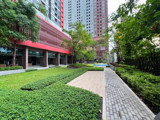 Modern residential building with landscaped pathway and recreational area
