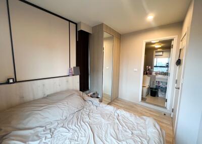 Modern bedroom with laminated flooring, large bed, and mirror wardrobe