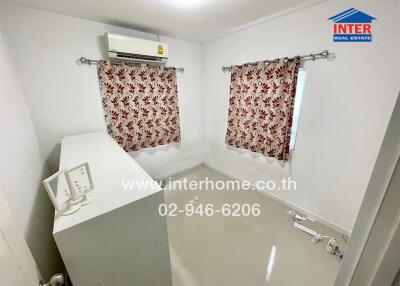 Compact laundry room with modern appliances and decorative curtains
