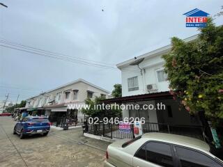 Residential street view showing a row of townhouses with clear sky