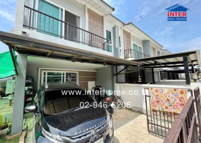 Front view of a modern two-story house with a car parked under a carport