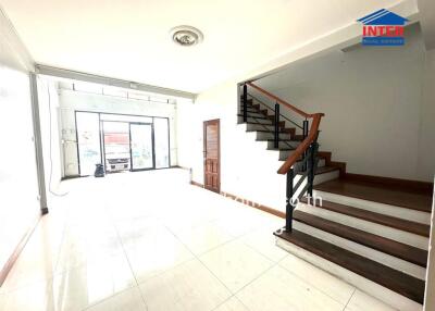 Spacious living room with staircase and abundant natural light