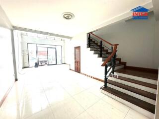 Spacious living room with staircase and abundant natural light