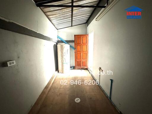 Spacious hallway with natural lighting and wooden door